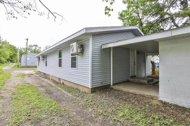 view of home's exterior with a cooling unit and driveway
