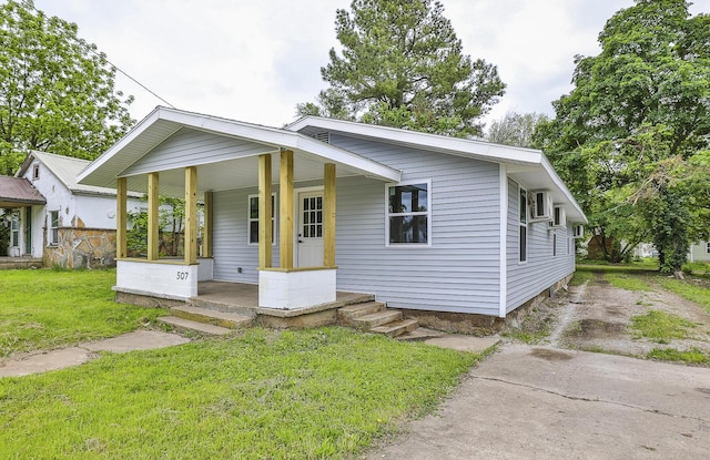 bungalow-style house with covered porch, a front yard, and driveway