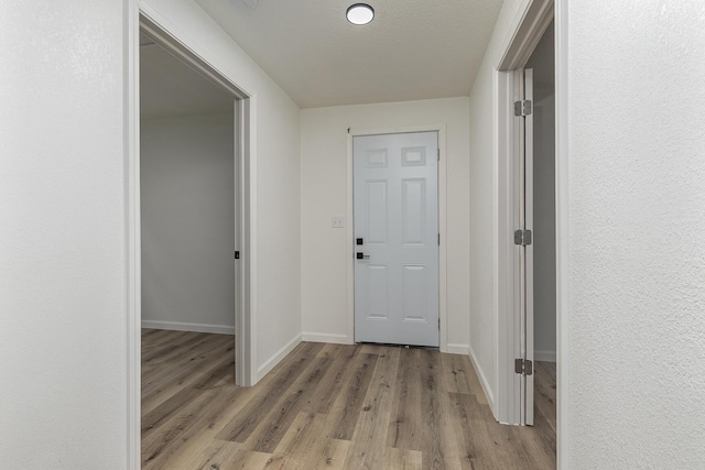 hallway with baseboards and wood finished floors