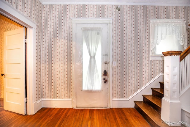 entrance foyer featuring wallpapered walls, wood-type flooring, and stairs
