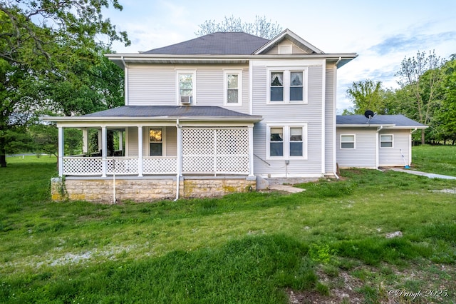 rear view of property featuring a lawn and roof with shingles