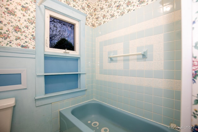 bathroom featuring wallpapered walls, a bath, toilet, a wainscoted wall, and a shower