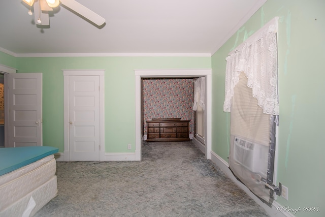 unfurnished bedroom featuring carpet flooring, crown molding, baseboards, cooling unit, and a ceiling fan