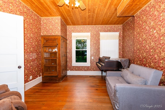 sitting room featuring wallpapered walls, hardwood / wood-style floors, wood ceiling, a ceiling fan, and baseboards