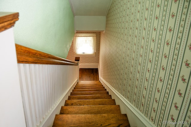 staircase featuring wallpapered walls and wood finished floors