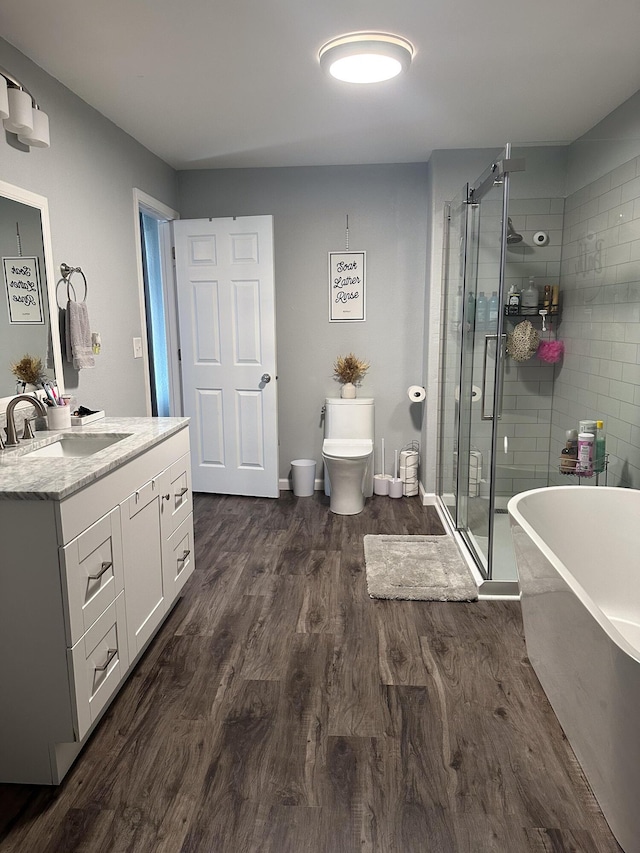 313 Washington St, Mountain View, MO 65548 - bathroom featuring a shower stall, wood finished floors, a freestanding bath, toilet, and vanity