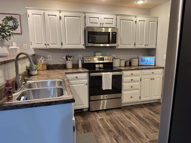 313 Washington St, Mountain View, MO 65548 - kitchen featuring appliances with stainless steel finishes, a sink, white cabinets, and dark wood finished floors