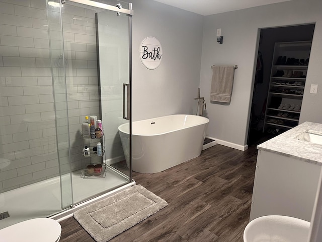 313 Washington St, Mountain View, MO 65548 - bathroom with a stall shower, a freestanding bath, wood finished floors, vanity, and baseboards
