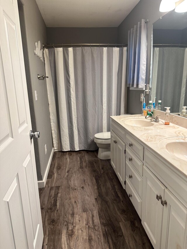 313 Washington St, Mountain View, MO 65548 - bathroom with wood finished floors, toilet, double vanity, and baseboards