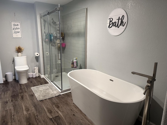 313 Washington St, Mountain View, MO 65548 - full bathroom with wood finished floors, a stall shower, toilet, and a soaking tub