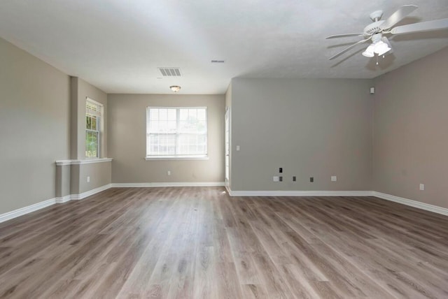 empty room featuring wood finished floors, ceiling fan, and baseboards
