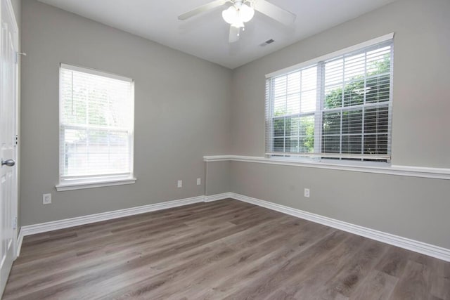 empty room featuring wood finished floors, baseboards, and ceiling fan