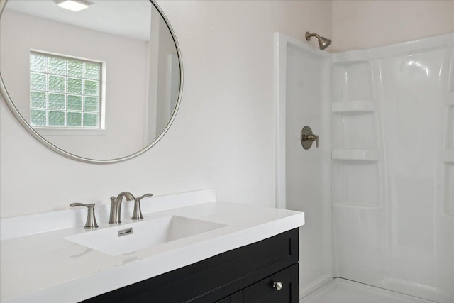 bathroom with a shower stall and vanity