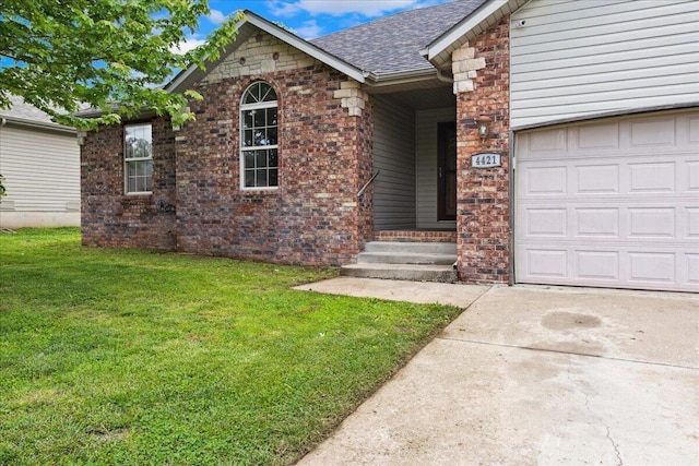 property entrance featuring a lawn, brick siding, an attached garage, and driveway