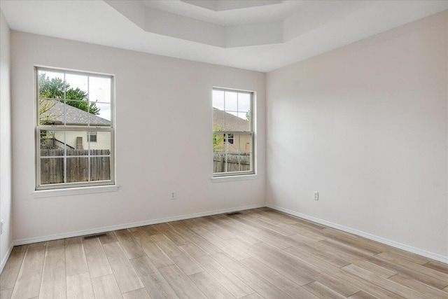 spare room featuring light wood-style flooring and baseboards