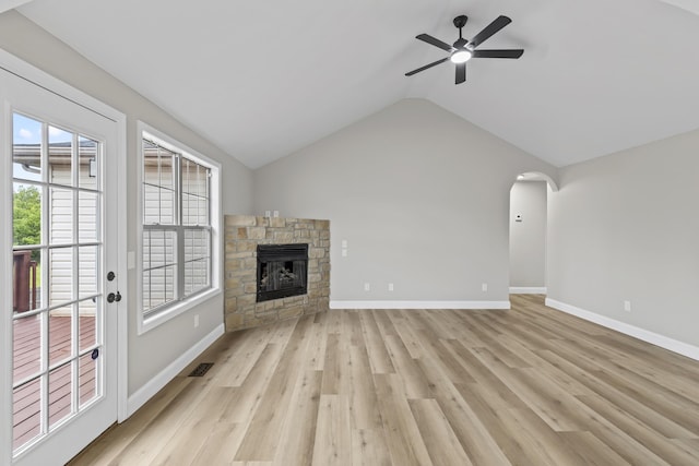 unfurnished living room featuring lofted ceiling, ceiling fan, light wood-style floors, baseboards, and a fireplace