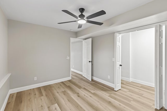 unfurnished bedroom with light wood-type flooring, baseboards, and ceiling fan