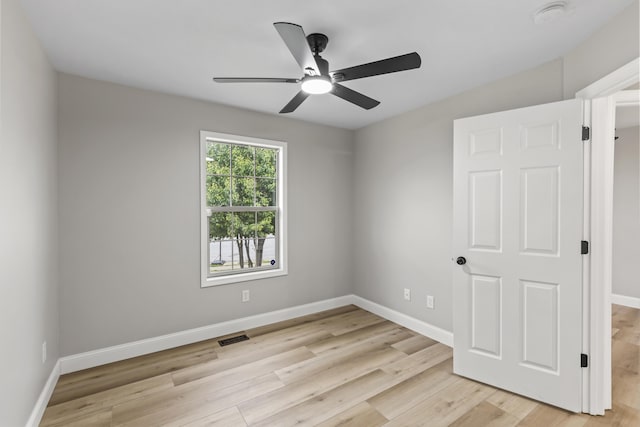 unfurnished room with a smoke detector, ceiling fan, light wood-style flooring, and baseboards