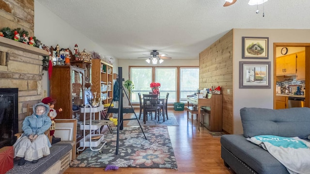 920 Oak St, Thayer, MO 65791 - living area featuring a ceiling fan, wood finished floors, a textured ceiling, and a fireplace