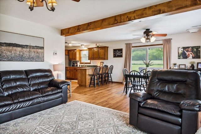1215 E 515th Rd, Morrisville, MO 65710 - living room featuring ceiling fan, light wood-style flooring, beamed ceiling, and a chandelier