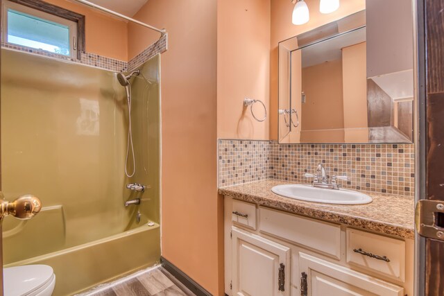 713 Taneycomo Rd, Branson, MO 65616 - bathroom with vanity, bathing tub / shower combination, decorative backsplash, and toilet