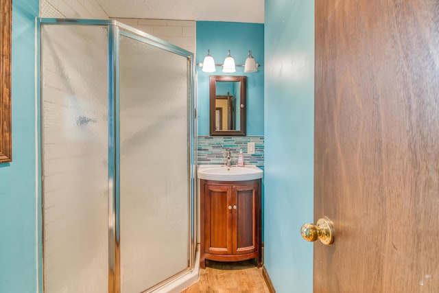 713 Taneycomo Rd, Branson, MO 65616 - full bathroom with a stall shower, wood finished floors, vanity, and tasteful backsplash