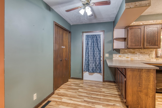 713 Taneycomo Rd, Branson, MO 65616 - kitchen with light wood-style flooring, a peninsula, tasteful backsplash, light countertops, and baseboards