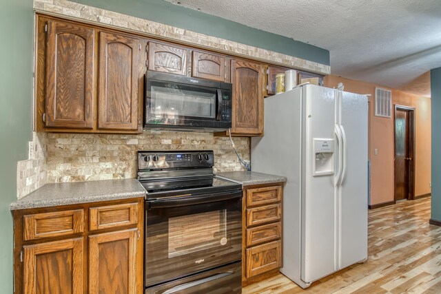713 Taneycomo Rd, Branson, MO 65616 - kitchen featuring black appliances, light wood-style flooring, tasteful backsplash, a textured ceiling, and light countertops