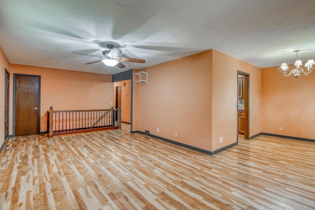 713 Taneycomo Rd, Branson, MO 65616 - spare room featuring light wood finished floors, ceiling fan, baseboards, and a chandelier