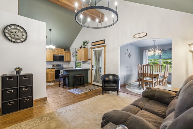 1226 Peace In Valley Rd, Blue Eye, MO 65611 - living area with a chandelier, a high ceiling, light wood-style flooring, baseboards, and arched walkways