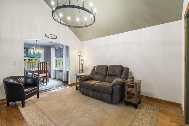 1226 Peace In Valley Rd, Blue Eye, MO 65611 - living area with a chandelier, wood finished floors, high vaulted ceiling, arched walkways, and baseboards