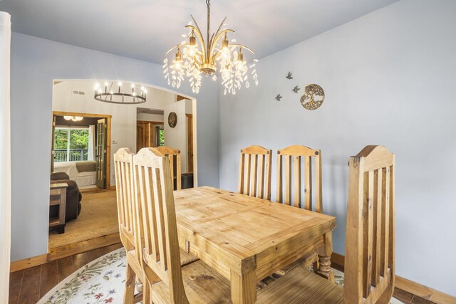 1226 Peace In Valley Rd, Blue Eye, MO 65611 - dining area with a chandelier, wood finished floors, and baseboards