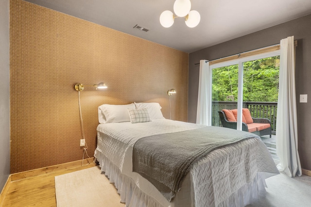 1226 Peace In Valley Rd, Blue Eye, MO 65611 - bedroom featuring access to exterior, a chandelier, baseboards, and wood finished floors