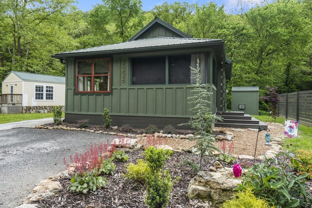 1226 Peace In Valley Rd, Blue Eye, MO 65611 - view of front of home with board and batten siding, an outbuilding, a shed, and fence