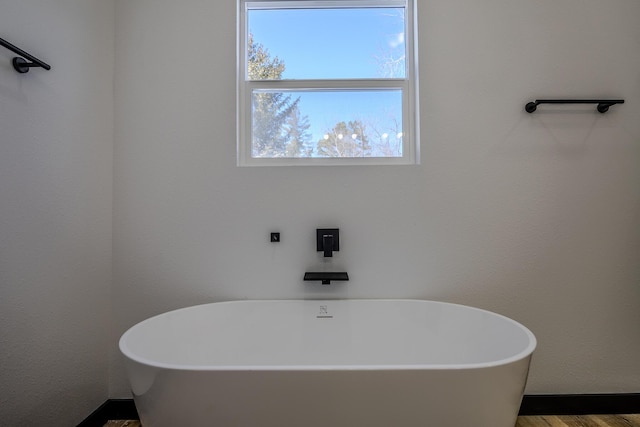 834 Morris St, Mountain Grove, MO 65711 - bathroom featuring a freestanding tub and wood finished floors