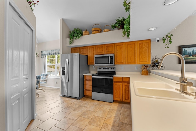 351 Wildwood Dr S Unit 5, Branson, MO 65616 - kitchen featuring appliances with stainless steel finishes, light countertops, lofted ceiling, brown cabinetry, and a sink