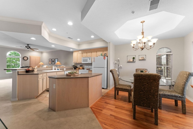 680 Emerald Pointe Dr Unit 6, Hollister, MO 65672 - kitchen featuring white appliances, a raised ceiling, crown molding, a center island, and a chandelier
