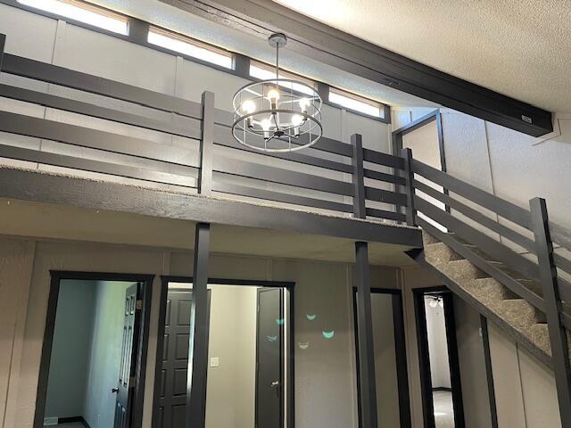 1627 W Lindberg St, Springfield, MO 65807 - stairway featuring a chandelier and a textured ceiling