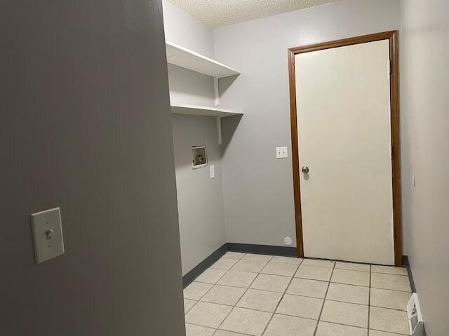 1627 W Lindberg St, Springfield, MO 65807 - laundry area featuring hookup for a washing machine, a textured ceiling, light tile patterned floors, and baseboards