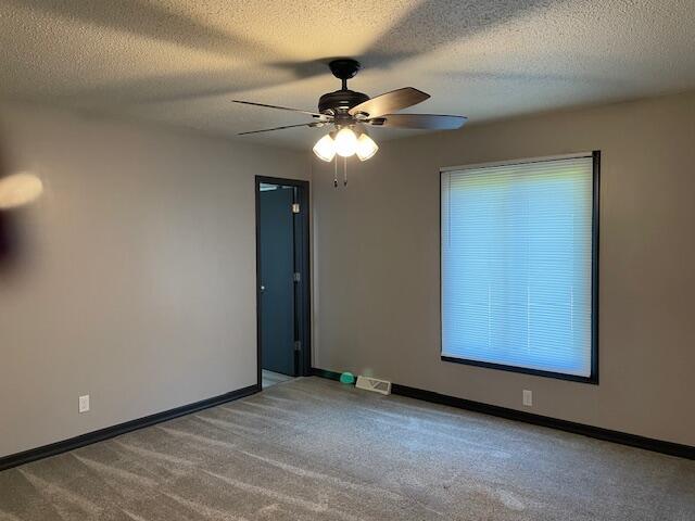 1627 W Lindberg St, Springfield, MO 65807 - carpeted empty room featuring a ceiling fan, baseboards, and a textured ceiling