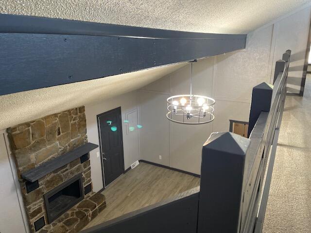 1627 W Lindberg St, Springfield, MO 65807 - detailed view of a textured ceiling, a chandelier, a stone fireplace, and wood finished floors