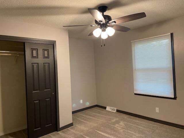 1627 W Lindberg St, Springfield, MO 65807 - unfurnished bedroom with light colored carpet, a textured ceiling, baseboards, a closet, and a ceiling fan