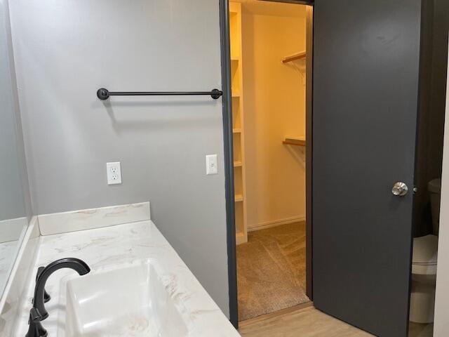 1627 W Lindberg St, Springfield, MO 65807 - bathroom featuring toilet, vanity, a walk in closet, and wood finished floors