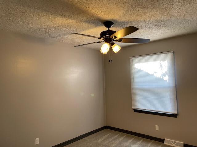 1627 W Lindberg St, Springfield, MO 65807 - empty room featuring ceiling fan, baseboards, a textured ceiling, and light carpet