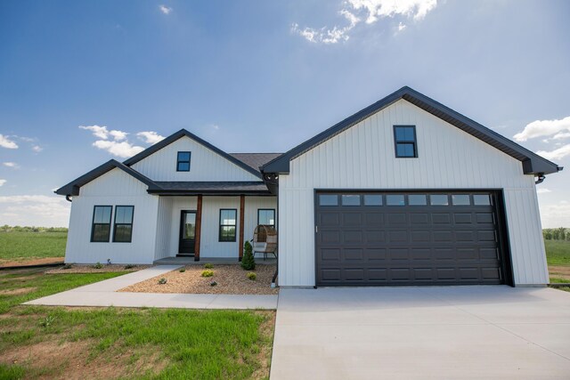 13320 E 1424th Rd, Stockton, MO 65785 - modern inspired farmhouse with covered porch, driveway, a garage, and roof with shingles