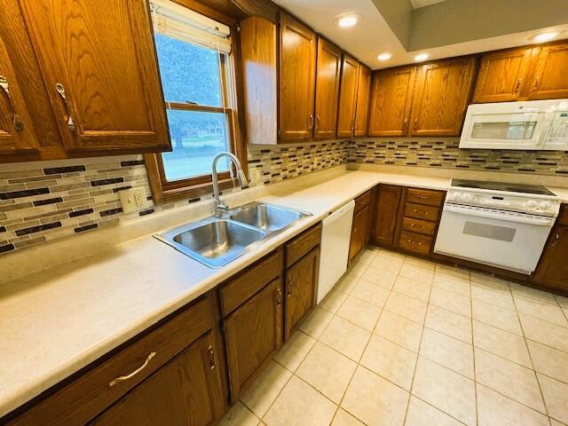 3820 S Virginia Pl, Springfield, MO 65807 - kitchen with white appliances, a sink, backsplash, and light countertops