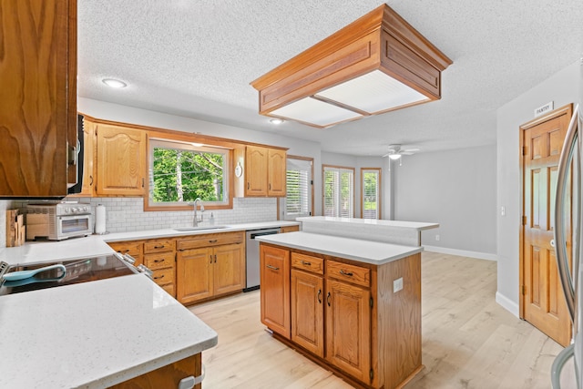 4823 S Buckingham Ln, Springfield, MO 65810 - kitchen featuring a sink, appliances with stainless steel finishes, light countertops, a kitchen island, and plenty of natural light