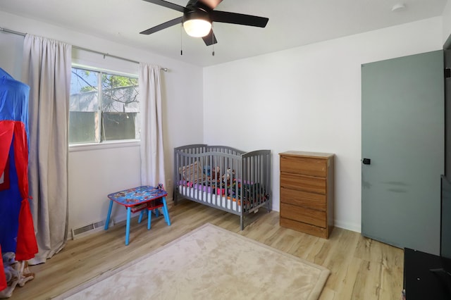 845 W Seminole St, Springfield, MO 65807 - bedroom featuring wood finished floors, a ceiling fan, and a crib