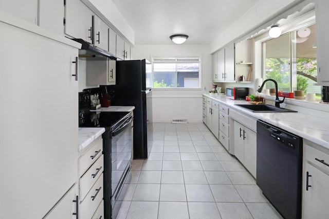 845 W Seminole St, Springfield, MO 65807 - kitchen featuring black appliances, a sink, under cabinet range hood, light tile patterned floors, and healthy amount of natural light