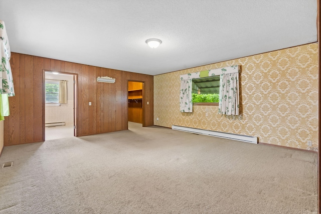 191 State Highway Y, Forsyth, MO 65653 - unfurnished living room featuring a baseboard radiator, carpet, wallpapered walls, a baseboard heating unit, and wood walls